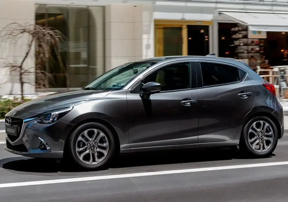 Mazda 2 Sport gris en movimiento por una calle de la ciudad.