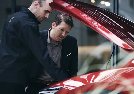 Auto Mazda color ojo con el capo abierto.